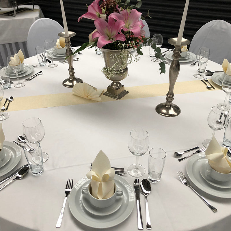 Elegante Eventausstattung Hochzeit Wismar mit festlich gedecktem Tisch, weißen Tischdecken und Blumenarrangement