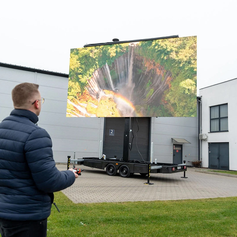 LED Trailer Veranstaltungstechnik mit großem Bildschirm im Freien neben einem Gebäude, Bedienung durch Person