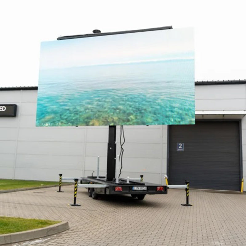 Mobiler LED Trailer Veranstaltungstechnik mit großem Outdoor-Bildschirm auf Parkplatz vor Lagerhalle