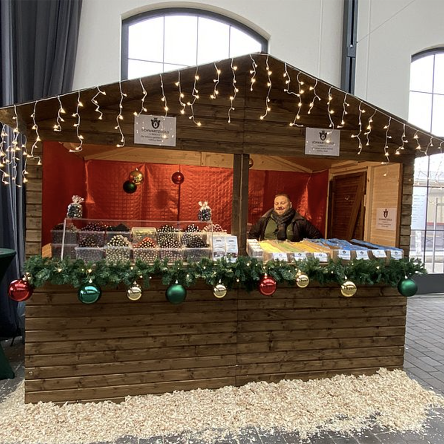 Weihnachtlich dekorierte Holzmarkthütte mit Lichterkette und festlicher Girlande zum Markthütte mieten