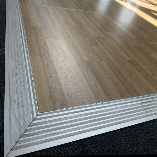 Ecke einer mobilen Tanzfläche mit Holzoptik und Metallumrandung zum mobile Tanzfläche mieten