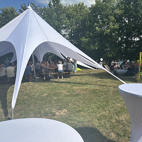 Großes weißes Sternenzelt mit Gästen bei sonnigem Wetter im Grünen Sternenzelt mieten Wismar
