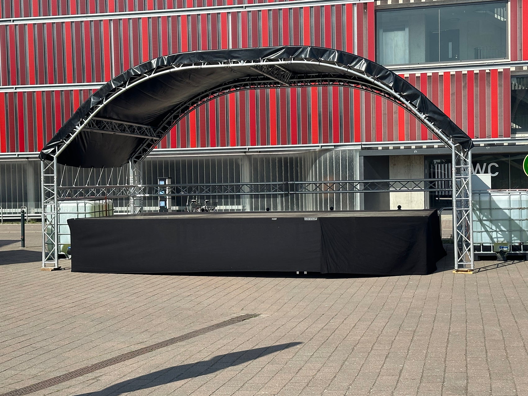 Moderne Rundbogenbühne mieten vom Anbieter Rental Hansekontor Wismar im urbanen Außenbereich